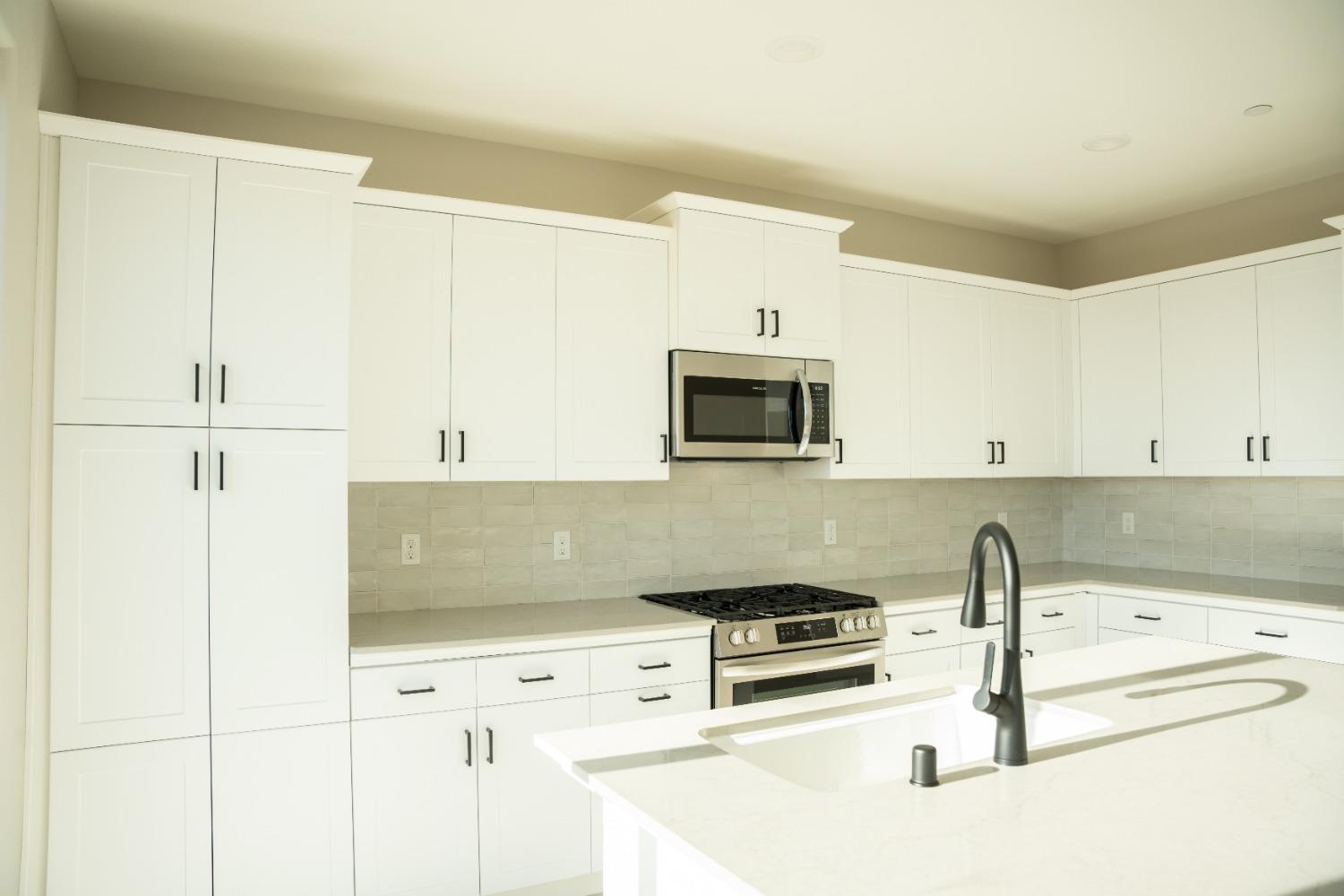 4107 Braden Road Madera, CA 93636 - Photo 2 of 17 a kitchen with white cabinets and sink