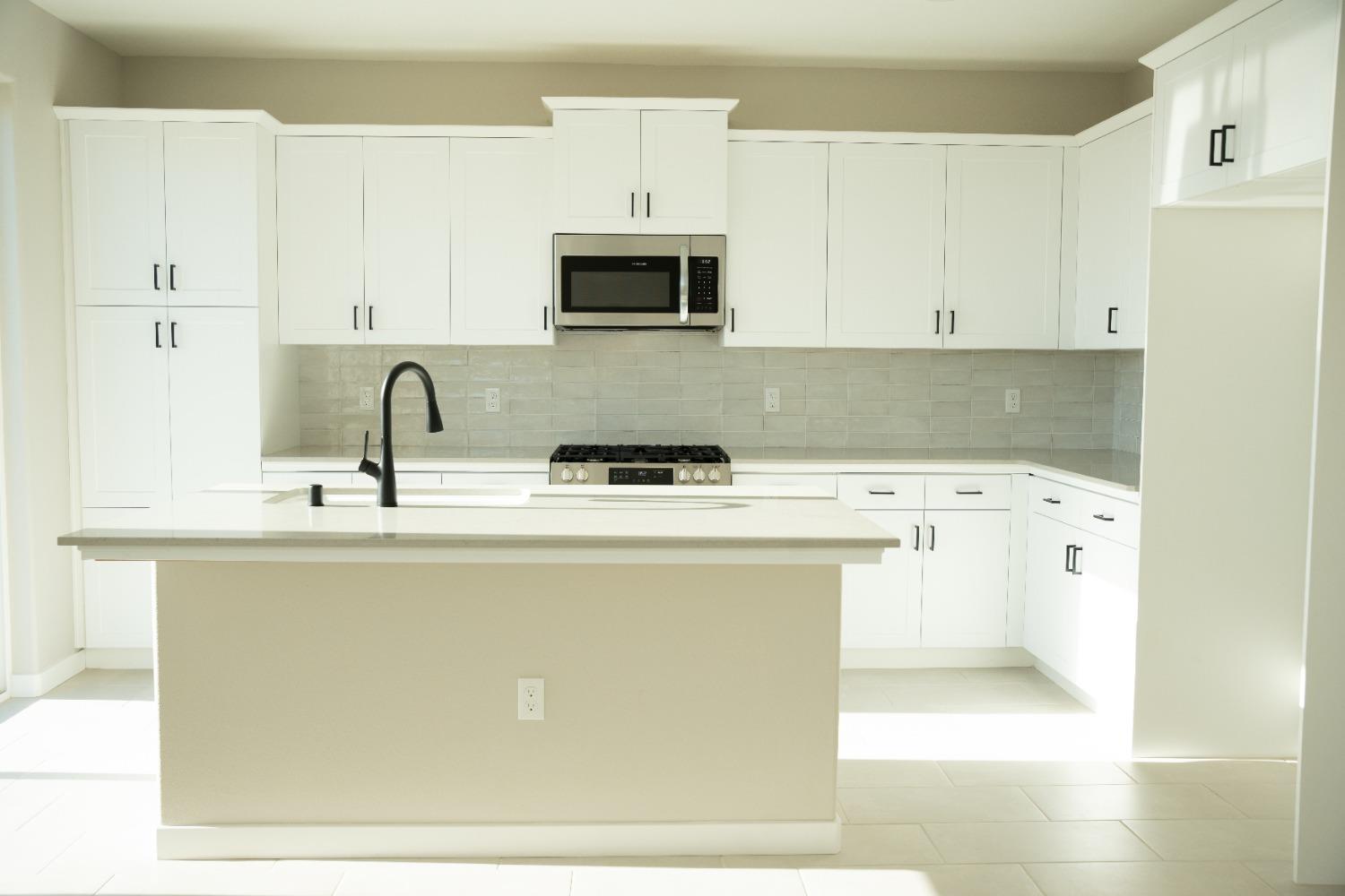4107 Braden Road Madera, CA 93636 - Photo 3 of 17 a close view of a sink a stove and a microwave in a kitchen