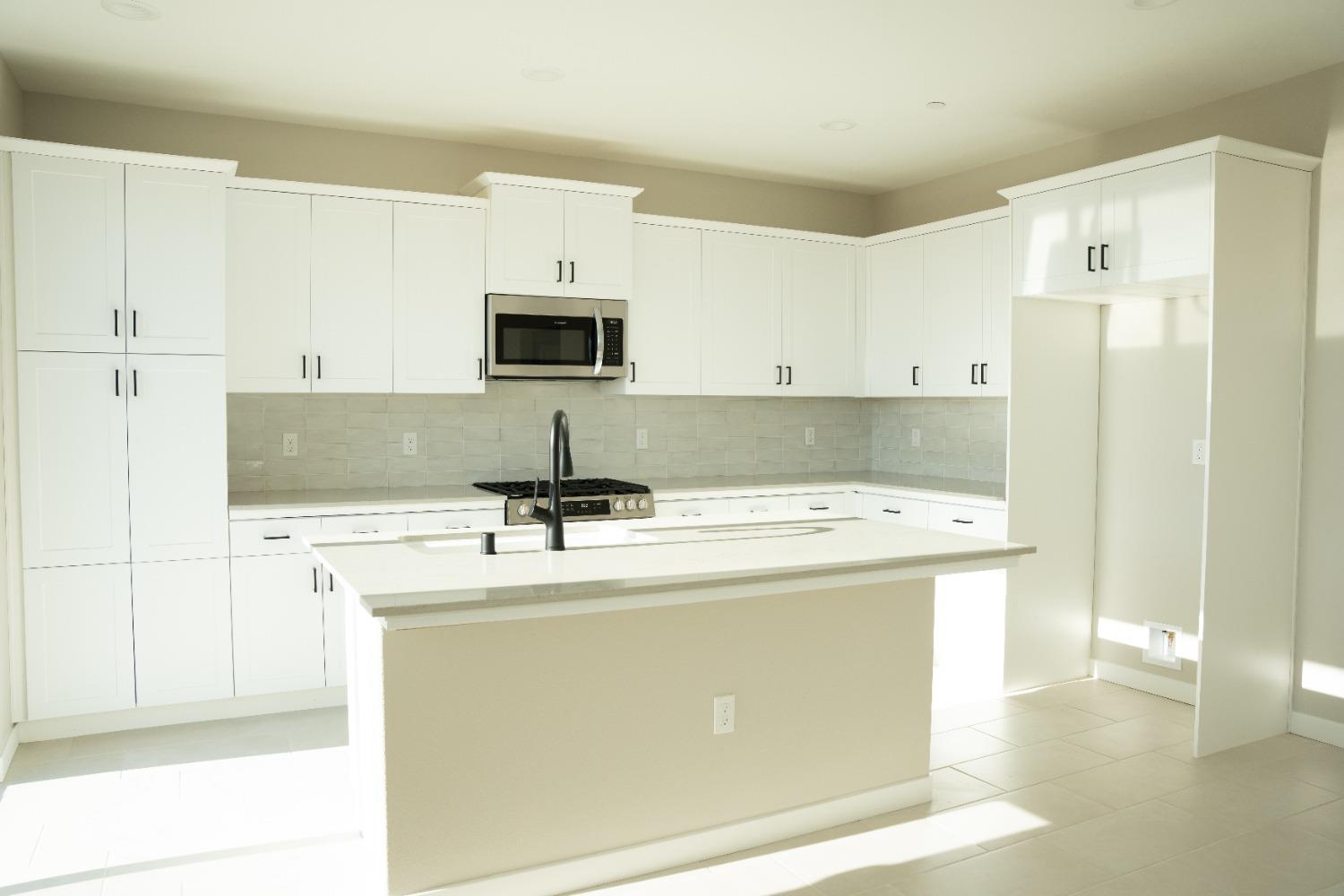 4107 Braden Road Madera, CA 93636 - Photo 4 of 17 a kitchen with stainless steel appliances a stove refrigerator sink and microwave