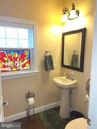 a bathroom with a toilet a sink and mirror
