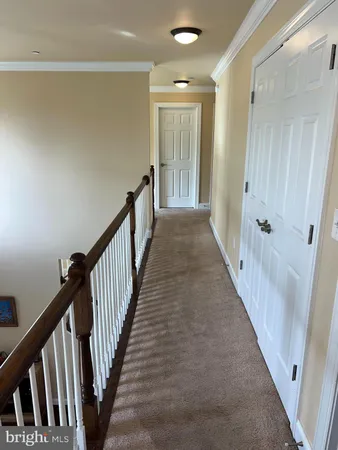 a view of a hallway with wooden floor and entryway