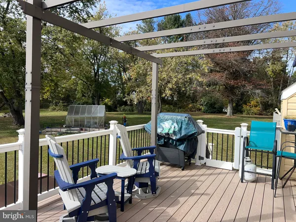 a view of deck with table and chairs a barbeque with wooden floor and fence