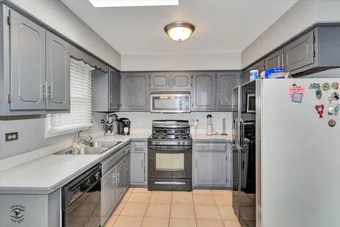 a kitchen with stainless steel appliances granite countertop a refrigerator sink and stove