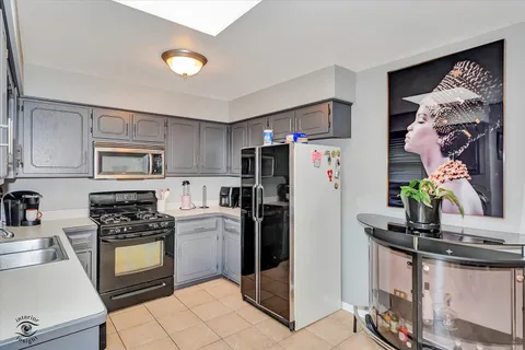 a kitchen with stainless steel appliances granite countertop a refrigerator sink and stove
