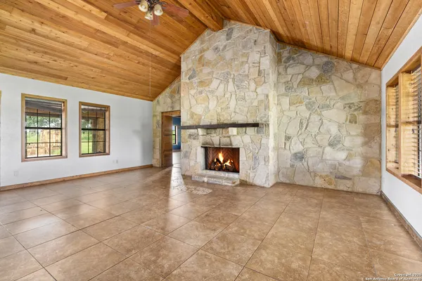 a view of an empty room with a fireplace and a window