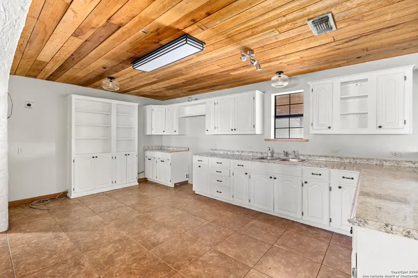 a kitchen with granite countertop a sink and cabinets