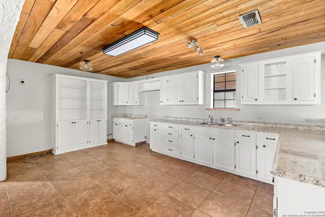 a kitchen with granite countertop a sink and cabinets