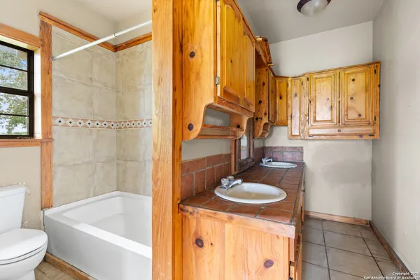 a bathroom with a sink a toilet a mirror and shower