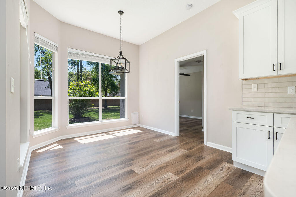 1984 Bluebonnet Way Fleming Island, FL 32003 - Photo 12 of 69 a view of an empty room with wooden floor and a window