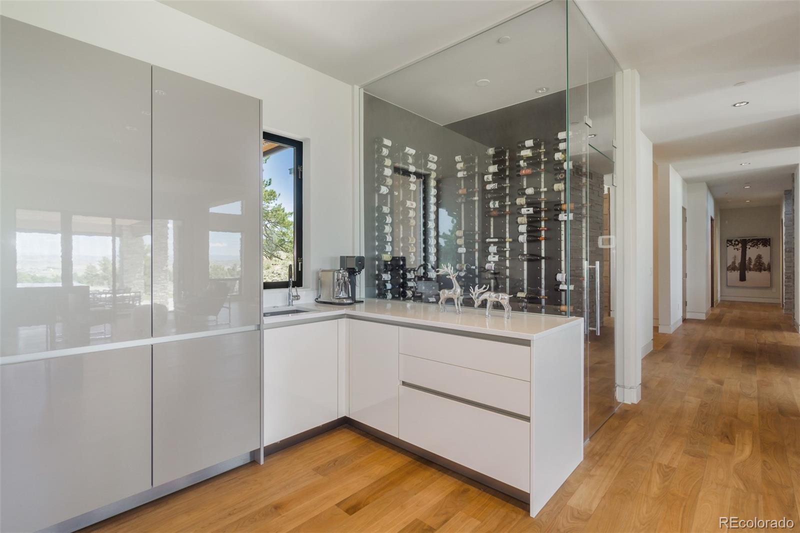 7895 Forest Keep Circle Parker, CO 80134 - Photo 11 of 40 a kitchen with white cabinets and wooden floor