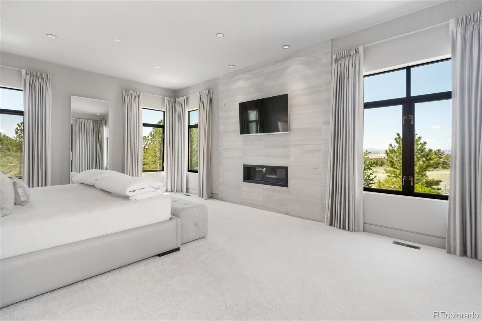 7895 Forest Keep Circle Parker, CO 80134 - Photo 24 of 40 a spacious bedroom with a large bed and a flat screen tv