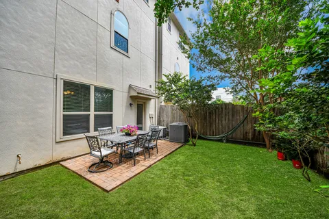 a view of backyard of house with outdoor seating and green space