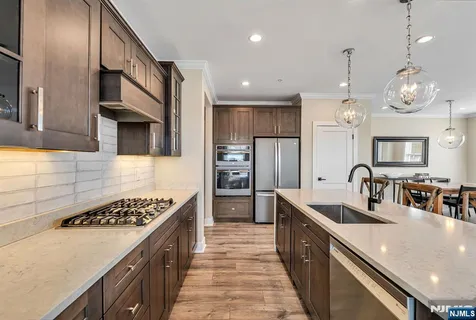 a kitchen with stainless steel appliances a sink stove and refrigerator