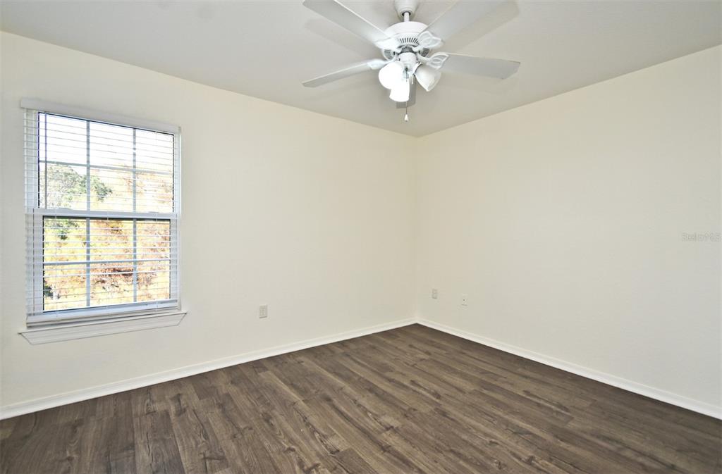 5467 Vineland Road, Unit 6308 Orlando, FL 32811 - Photo 11 of 39 an empty room with wooden floor and windows