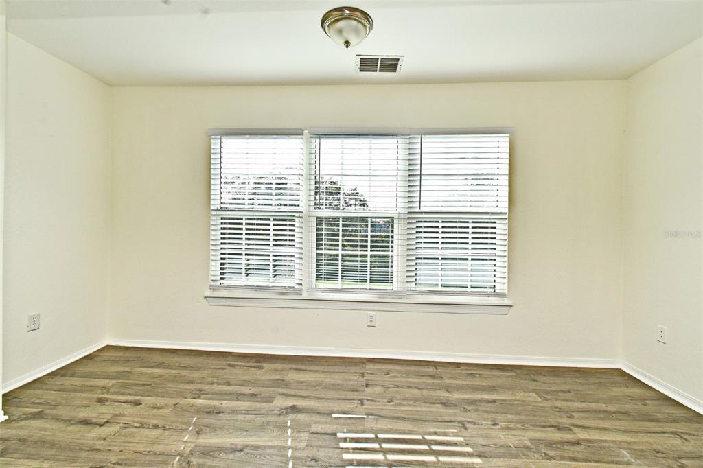 5467 Vineland Road, Unit 6308 Orlando, FL 32811 - Photo 16 of 39 a view of an empty room with wooden floor and a window