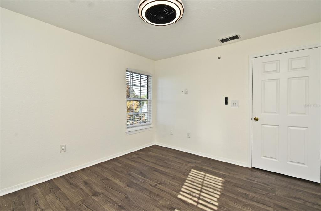 5467 Vineland Road, Unit 6308 Orlando, FL 32811 - Photo 3 of 39 an empty room with wooden floor and windows