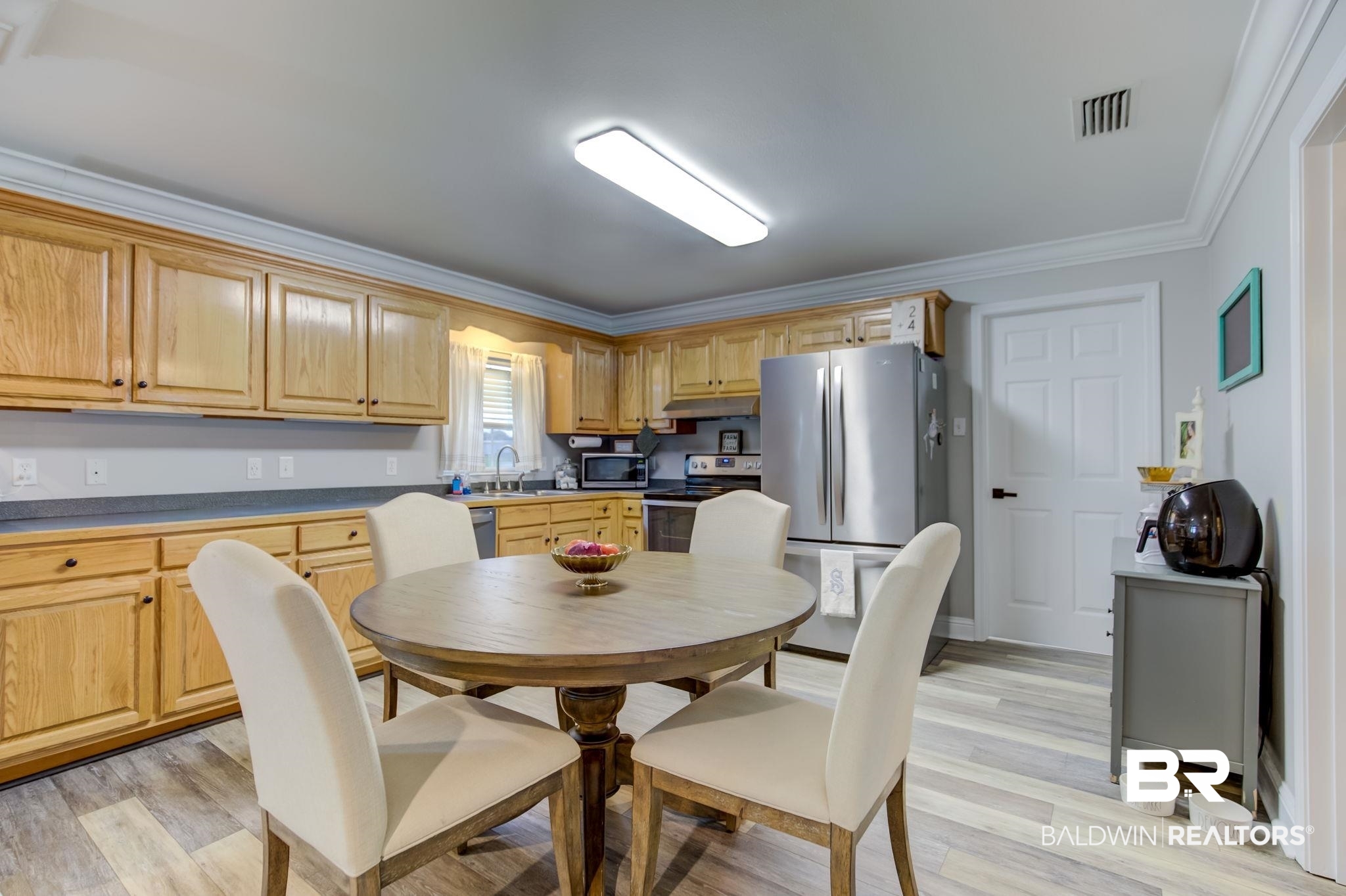 18732 Fairground Road Robertsdale, AL 36567 - Photo 11 of 46 Dining room with crown molding, sink, and light wood-type flooring
