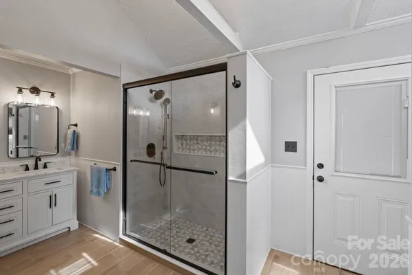 a bathroom with a shower sink and mirror