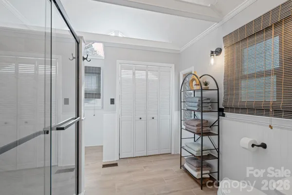 a spacious bathroom with a granite countertop toilet a sink a mirror and shower