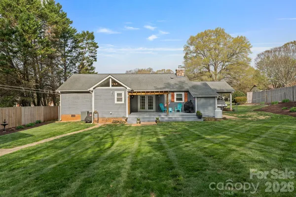 a front view of a house with a yard and trees
