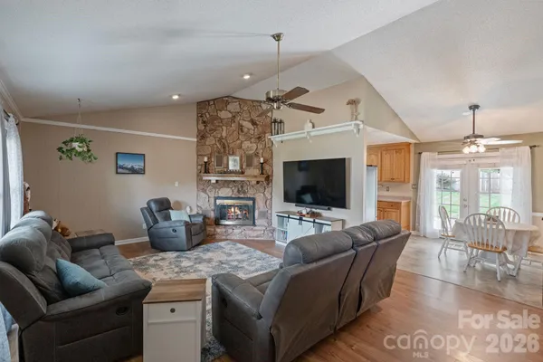 a living room with furniture a flat screen tv and a chandelier