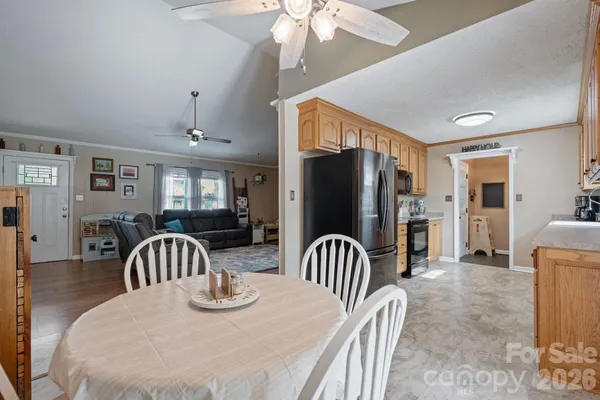 a kitchen with sink refrigerator dining table and chairs