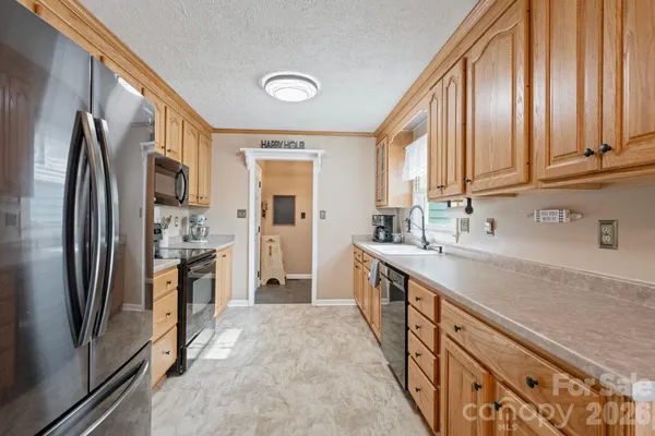 a kitchen with stainless steel appliances granite countertop a refrigerator a stove and a sink with cabinets
