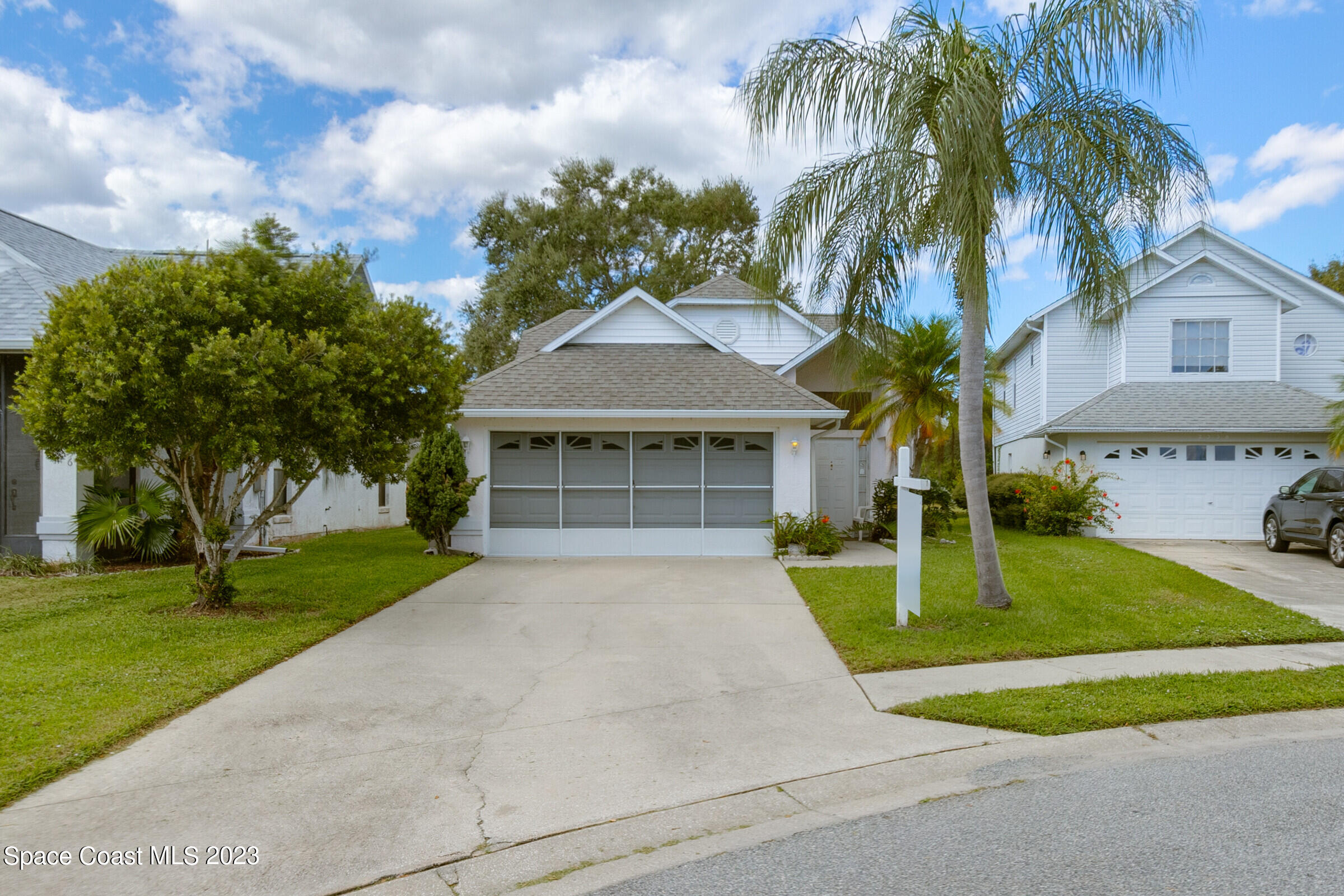 a front view of a house with a garden and trees