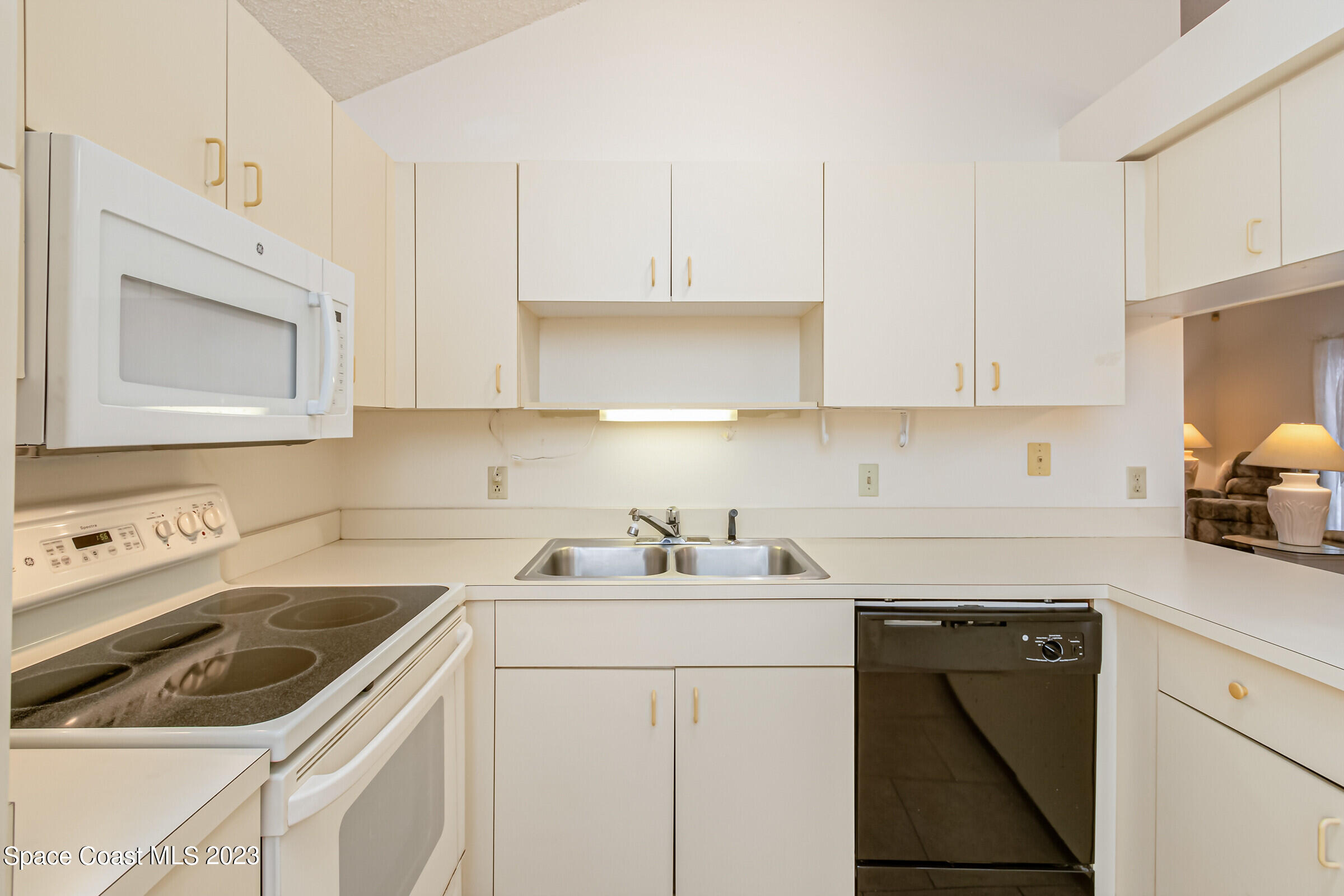 2332 Skywind Circle Melbourne, FL 32935 - Photo 17 of 34 a kitchen with white cabinets sink and white appliances