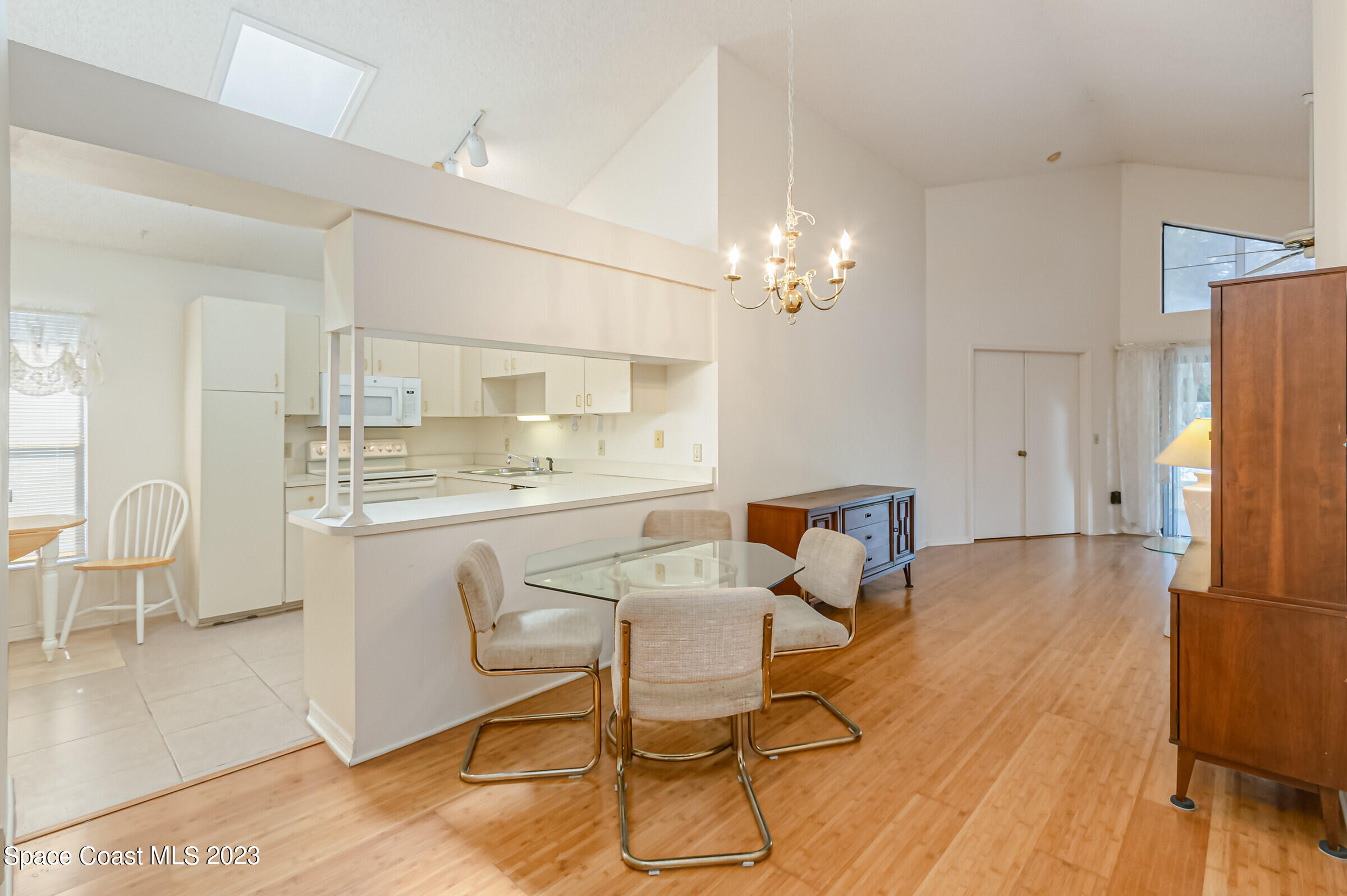 2332 Skywind Circle Melbourne, FL 32935 - Photo 20 of 34 a dining room with wooden floor and chandelier