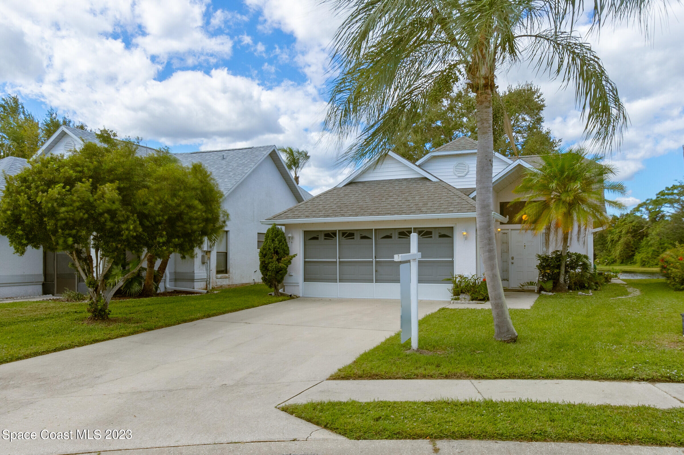 2332 Skywind Circle Melbourne, FL 32935 - Photo 2 of 34 a front view of a house with a garden and trees