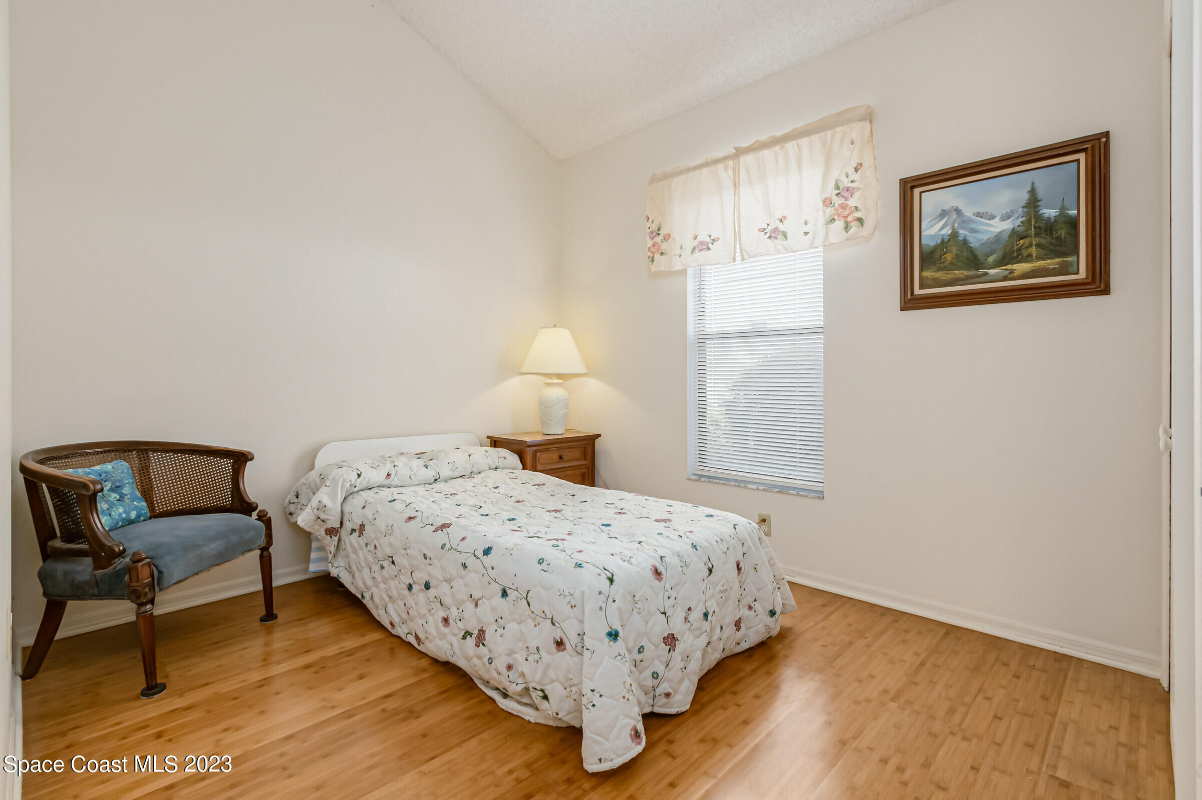 2332 Skywind Circle Melbourne, FL 32935 - Photo 23 of 34 a bedroom with a bed a chair and painting on the wall