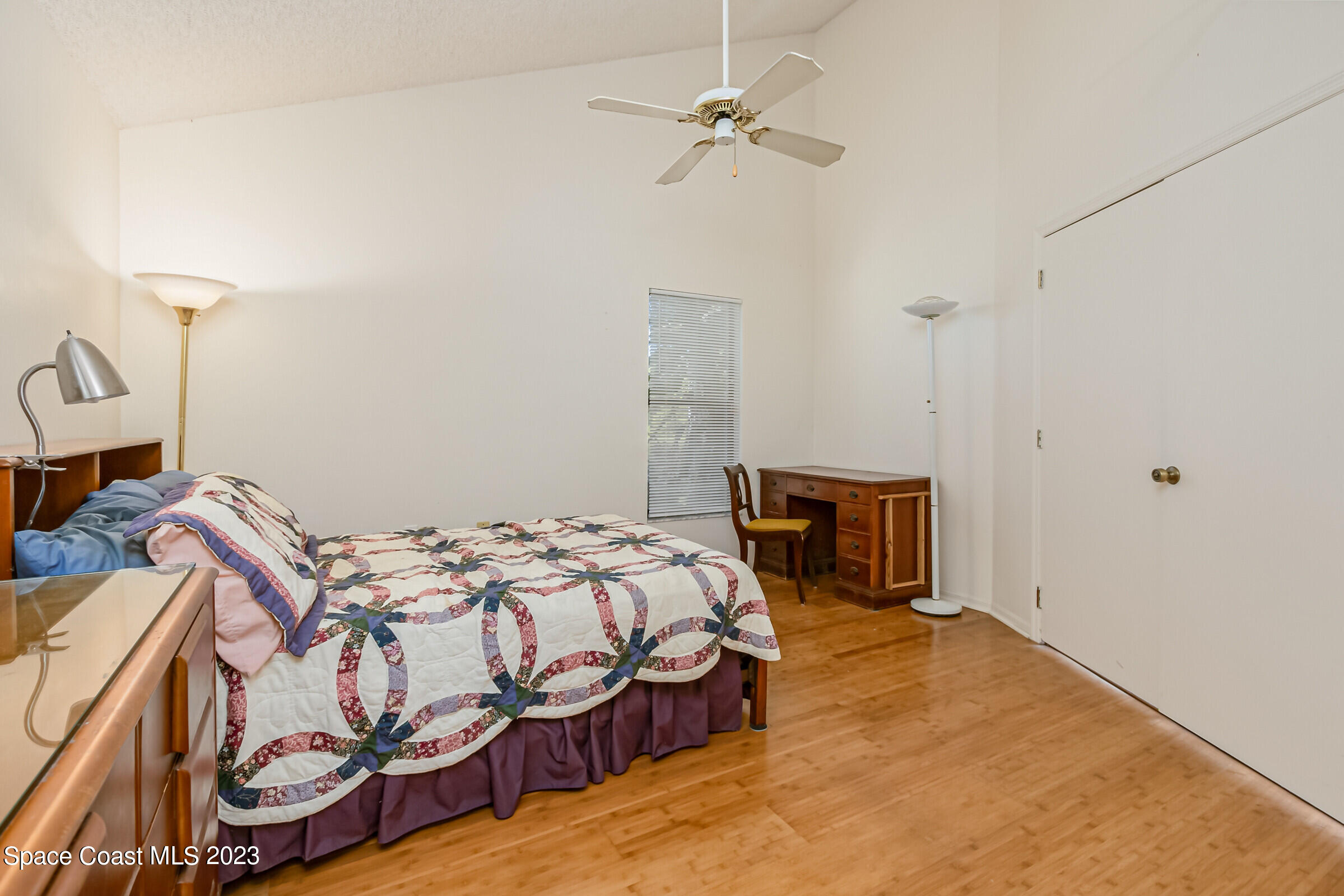 2332 Skywind Circle Melbourne, FL 32935 - Photo 26 of 34 a bedroom with a bed and a chandelier