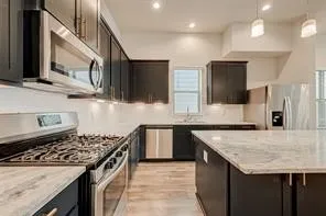 a kitchen with stainless steel appliances granite countertop a sink stove and refrigerator