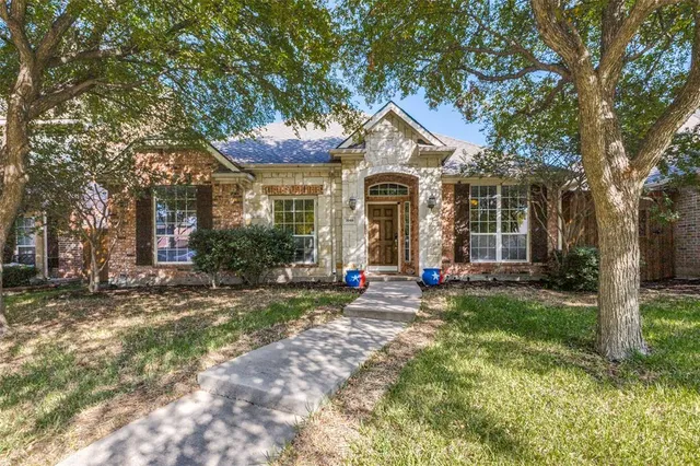 a view of a brick house with many windows and a big yard