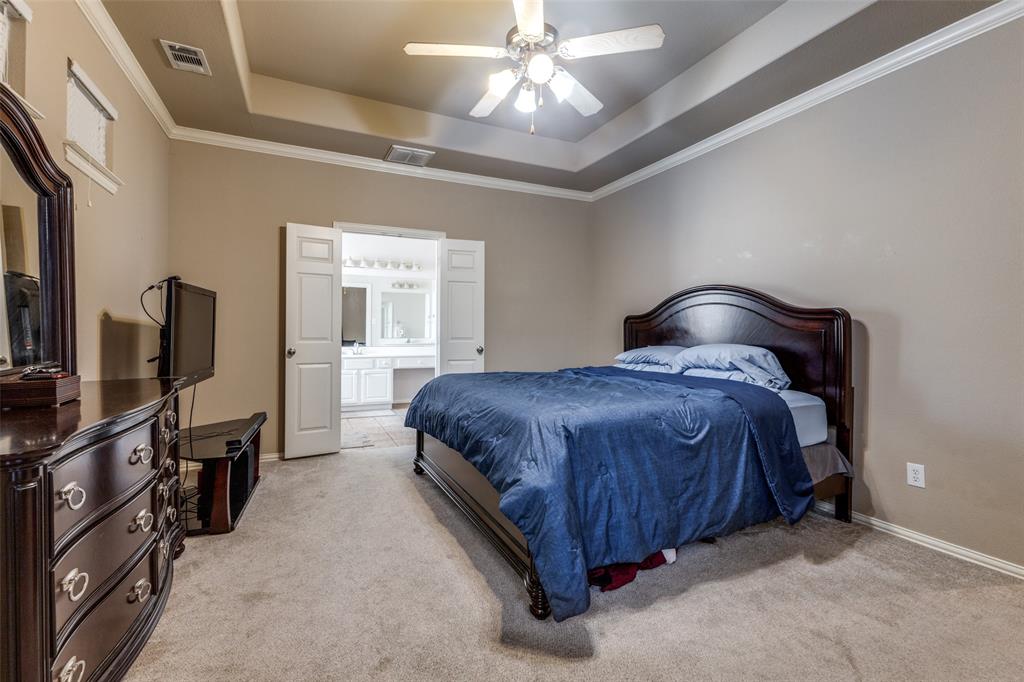 1046 Gold Camp Road Frisco, TX 75033 - Photo 12 of 25 a bedroom with a bed flat screen tv and a chandelier