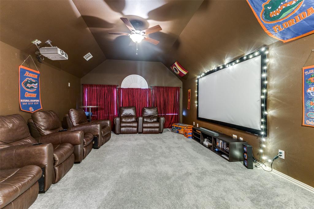 1046 Gold Camp Road Frisco, TX 75033 - Photo 17 of 25 a living room with furniture a chandelier and a flat screen tv