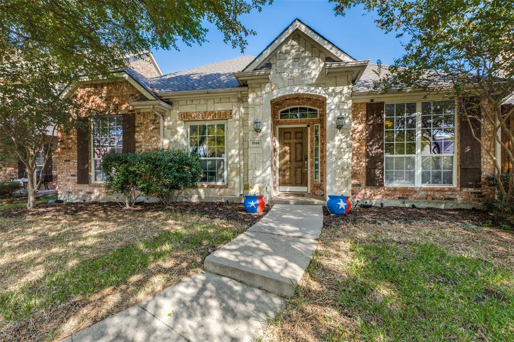 1046 Gold Camp Road Frisco, TX 75033 - Photo 2 of 25 a view of a brick house with large windows and a small yard