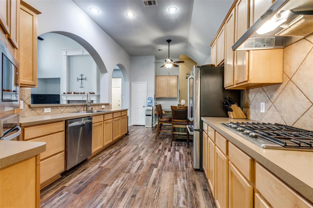 1046 Gold Camp Road Frisco, TX 75033 - Photo 7 of 25 a kitchen with stainless steel appliances a stove sink and cabinets
