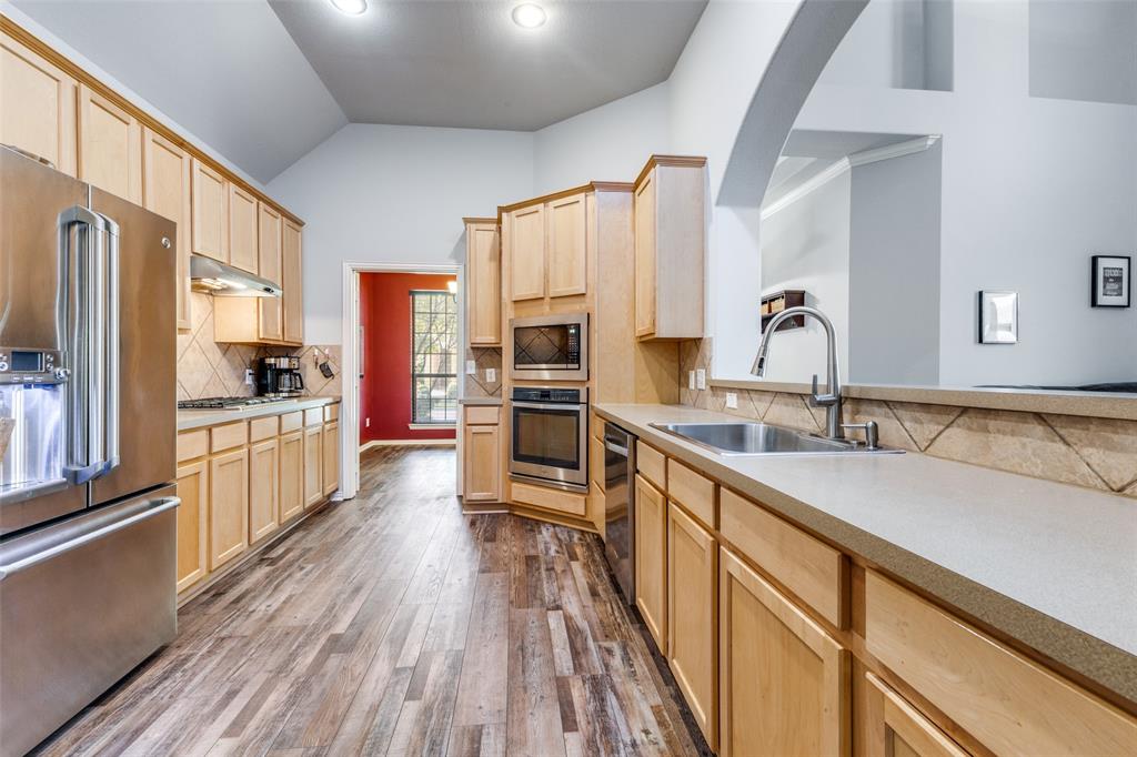 1046 Gold Camp Road Frisco, TX 75033 - Photo 9 of 25 a kitchen with stainless steel appliances granite countertop a sink stove and refrigerator