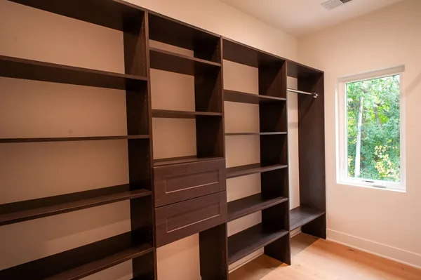 a view of walk in closet with empty racks