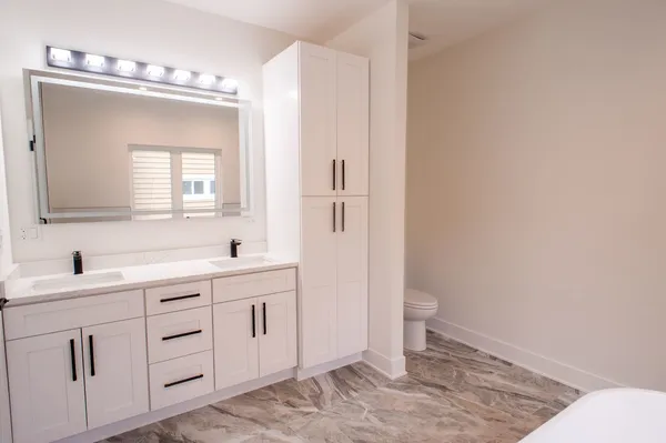 a bathroom with a sink a toilet and a mirror