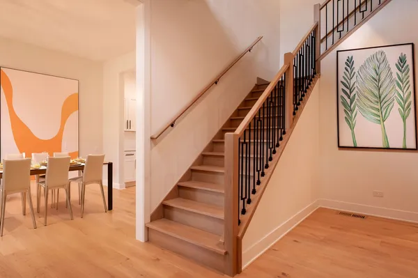a view of staircase with lots of frames on wall and a painting