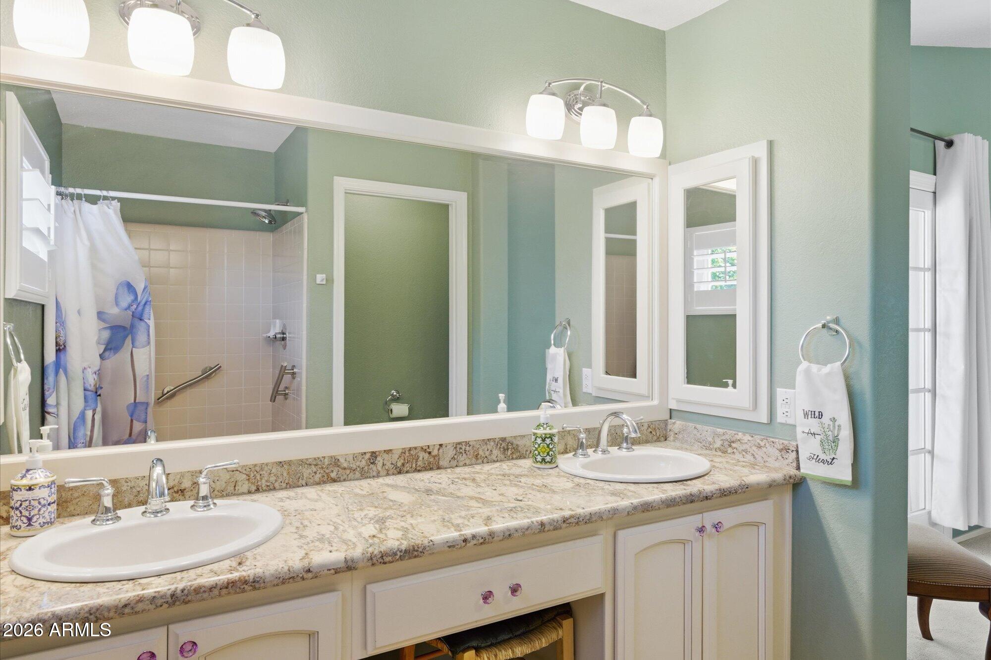 3895 North 150th Lane Goodyear, AZ 85395 - Photo 16 of 34 a bathroom with a granite countertop sink double and mirror