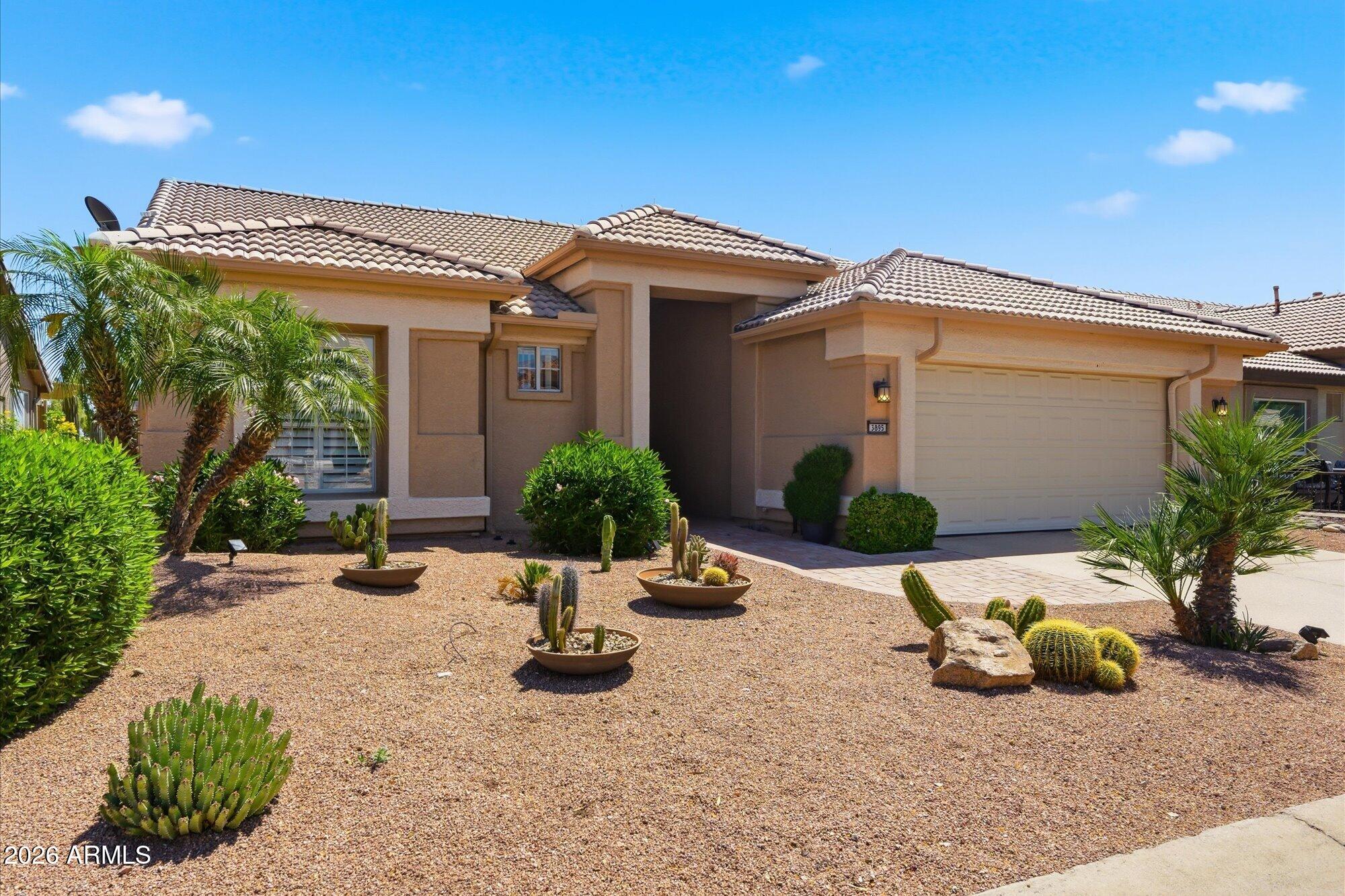 3895 North 150th Lane Goodyear, AZ 85395 - Photo 31 of 34 a view of a house with potted plants and a bench