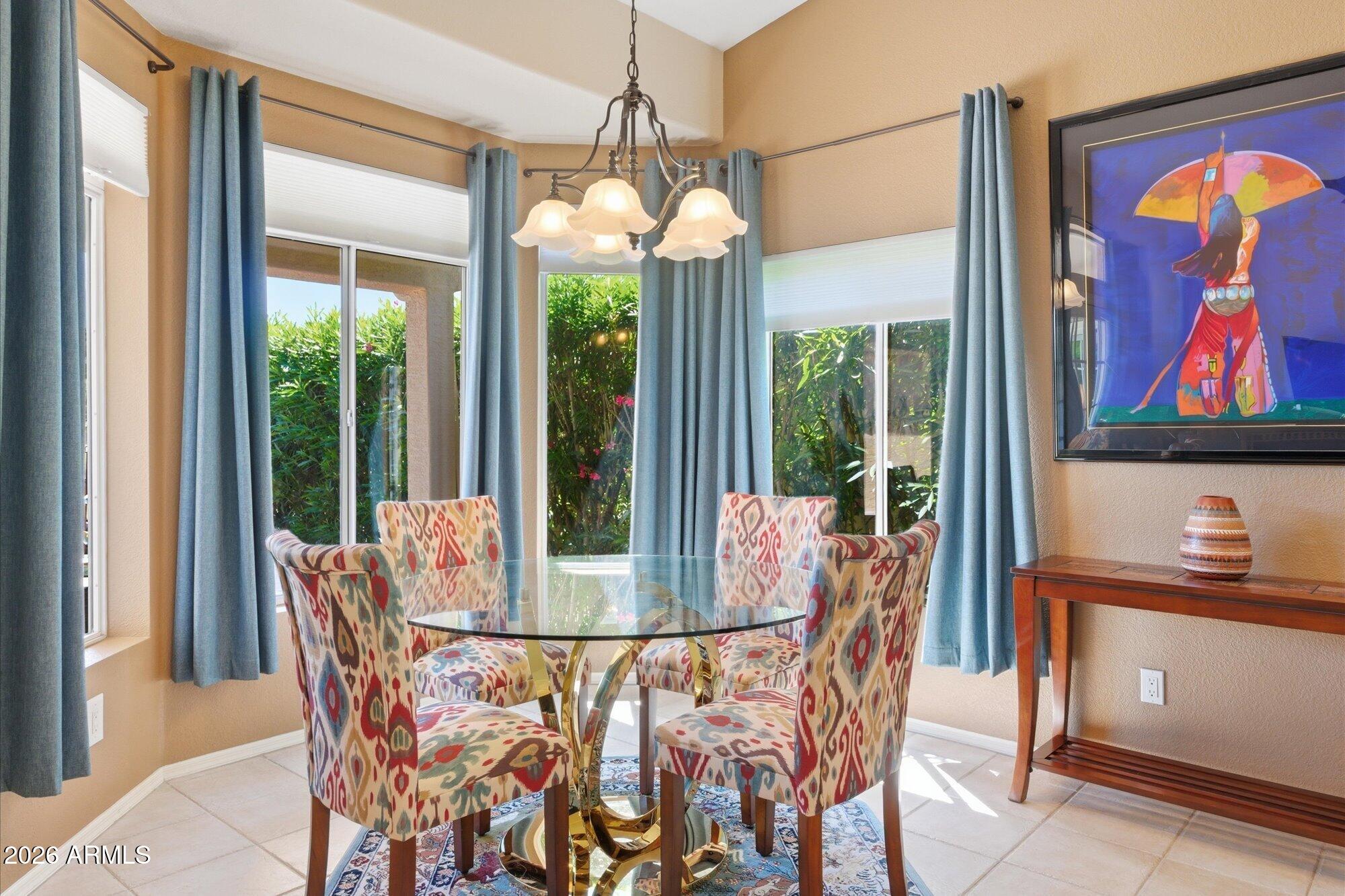 3895 North 150th Lane Goodyear, AZ 85395 - Photo 9 of 34 a dining room with furniture a chandelier and wooden floor