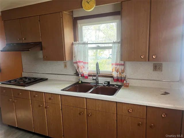 a kitchen with cabinets a window and stainless steel appliances