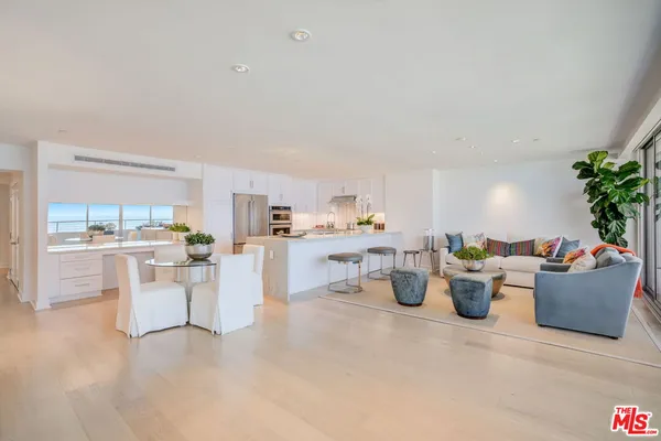 a living room with stainless steel appliances kitchen island granite countertop furniture and a view of kitchen