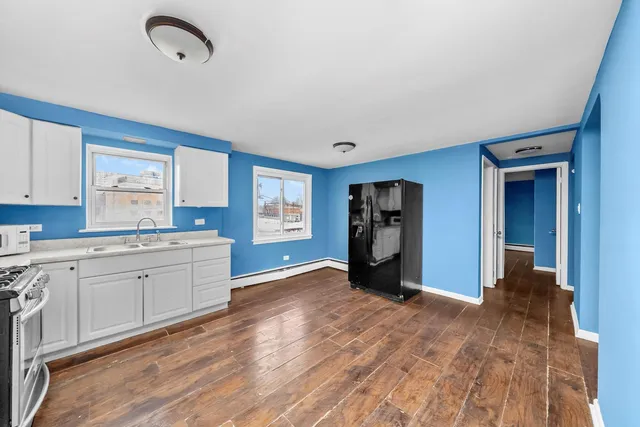 a kitchen with granite countertop a refrigerator and a stove top oven