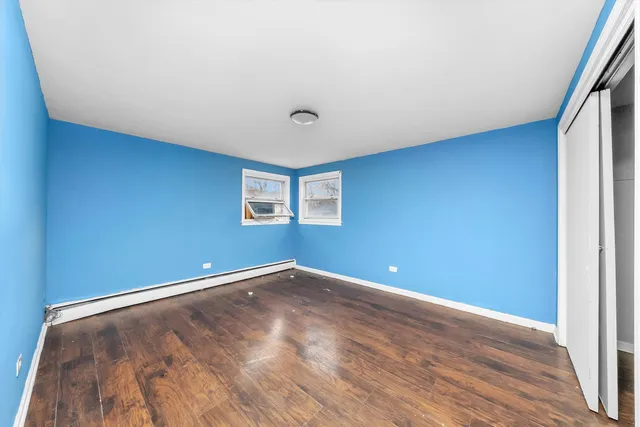 a view of a big room with wooden floor and windows